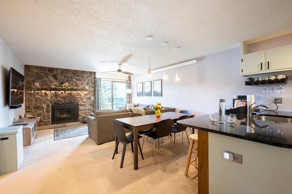 The great room at The Jabberwocky, with a gas fireplace and forest views